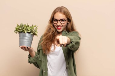 Tatmin olmuş, kendine güvenen, dostça gülümseyen ve seni seçen sarışın bir kadın.