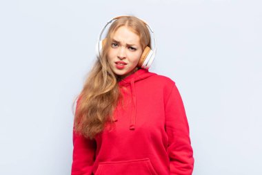 blonde woman feeling puzzled and confused, with a dumb, stunned expression looking at something unexpected