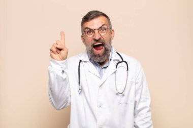 Bir fikri fark ettikten sonra mutlu ve heyecanlı bir dahi gibi hisseden yetişkin bir adam, neşeli bir şekilde parmağını kaldırıyor, eureka!