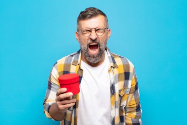 Yetişkin bir adam agresif bir şekilde bağırıyor, sinirli, sinirli, öfkeli ya da sinirli görünüyor.