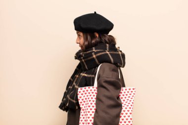 İspanyol kadın profil görünümünde ileriyi kopyalamaya çalışıyor, düşünüyor, hayal ediyor ya da hayal kuruyor.