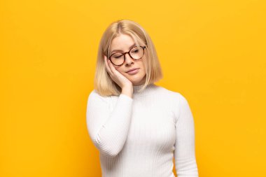 Sarışın kadın sıkılmış, hayal kırıklığına uğramış ve uykulu. Yorucu, sıkıcı ve can sıkıcı bir işten sonra, el ele tutuşarak.