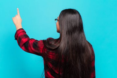 Kopyalama alanı ve dikiz görünümünde duran ve objeyi işaret eden Latin kadın