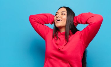 Latin kadın gülümsüyor ve rahatlıyor, tatmin oluyor ve kaygısız, neşeli ve rahatlatıcı.