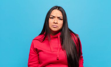 Üzgün ve mızmız bir Latin kadın, mutsuz bir bakışla, olumsuz ve hayal kırıklığına uğramış bir tavırla ağlıyor.