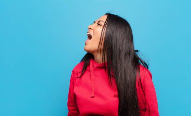 Latin kadın öfkeyle bağırıyor, agresif bir şekilde bağırıyor, stresli ve kızgın görünüyor.