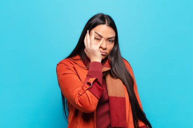 Sıkılmış, hayal kırıklığına uğramış ve uykulu hisseden Latin bir kadın yorucu, sıkıcı ve can sıkıcı bir işin ardından, el ele tutuşarak