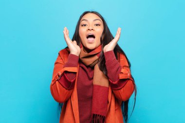 Latin bir kadın beklenmedik bir sürpriz yüzünden şaşkın, heyecanlı, gülen, şaşkın ve mutlu hissediyor.