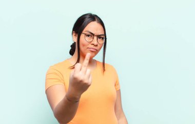 Latin kadın kızgın, sinirli, asi ve agresif hissediyor, orta parmağını sallıyor, karşı koyuyor.