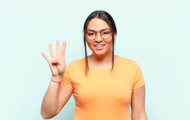 Latin bir kadın gülümsüyor ve arkadaş canlısı görünüyor. Elleri önde, geriye doğru sayıyor.