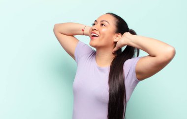 Latin kadın gülümsüyor ve rahatlıyor, tatmin oluyor ve kaygısız, neşeli ve rahatlatıcı.