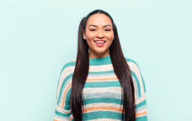 Latin kadın mutlu ve hoş bir şekilde şaşırmış görünüyor. Büyülenmiş ve şok olmuş bir ifadeyle heyecanlanıyor.