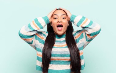 Latin bir kadın el ele tutuşuyor, ağzı açık, son derece şanslı, şaşırmış, heyecanlı ve mutlu.