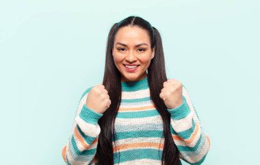 Latin kadın muzaffer bir şekilde bağırıyor, gülüyor, mutlu ve heyecanlı hissediyor başarıyı kutlarken