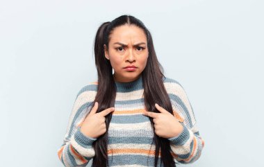 Kafası karışık ve tuhaf bakışlarıyla kendini işaret eden Latin kadın seçilmiş olmasına şaşırdı ve şaşırdı.