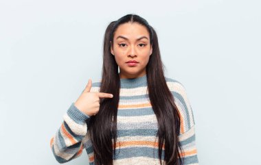 Kafası karışmış, kafası karışmış ve kendine güveni olmayan Latin bir kadın kendini gösterip kim olduğunu soruyor, ben mi??