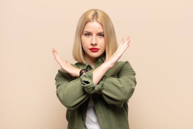 Sarışın kadın senin tavırlarından rahatsız ve bıkkın görünüyor, yeter artık! Eller önde çapraz, durmanı söylüyor.