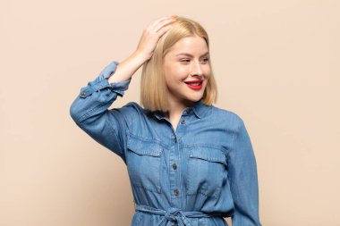 Sarışın kadın neşeli ve tesadüfen gülümsüyor, olumlu, mutlu ve kendinden emin bir bakışla kafa kafaya tutuşuyor.