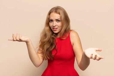 Sarışın kadın bilgisiz ve kafası karışık, hangi seçeneği seçeceğinden emin değil, merak ediyor.