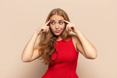 Sarışın kadın konsantre olmuş ve bir fikir üzerinde kafa yoruyor, bir soruna ya da soruna bir çözüm hayal ediyor.