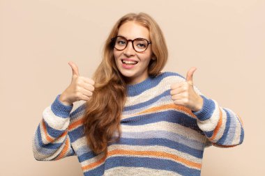 Sarışın kadın mutlu, pozitif, kendinden emin ve başarılı bir şekilde gülümsüyor.