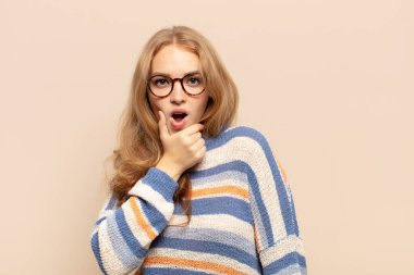 Sarışın, ağzı ve gözleri açık ve eli çenesinde olan bir kadın. Hoş olmayan bir şok geçiriyor. Ne diyor?