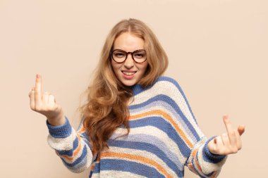 Sarışın kadın kışkırtıcı, agresif ve müstehcen hissediyor. İsyankar bir tavırla orta parmağını hareket ettiriyor.