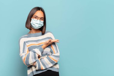 Genç İspanyol kadın neşeyle gülümsüyor, mutlu hissediyor ve fotokopi uzayda bir konsept gösteriyor.