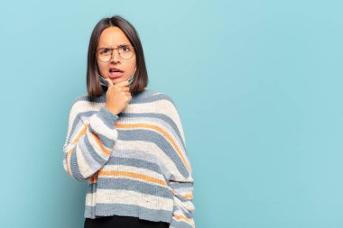 Ağzı ve gözleri sonuna kadar açık, eli çenesinde genç İspanyol bir kadın. Hoş olmayan bir şok geçiriyor.