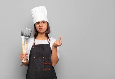 Genç İspanyol kadın kızgın, sinirli, asi ve agresif hissediyor. Orta parmağını sallıyor, karşı koyuyor.