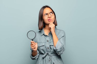 Genç İspanyol kadın düşünüyor, kuşkulu ve şaşkın hissediyor, farklı seçeneklerle, hangi kararı vereceğini merak ediyor.