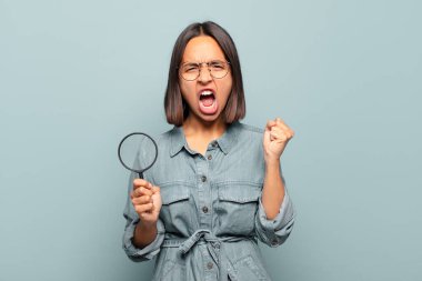 Genç İspanyol kadın öfkeli bir ifadeyle ya da yumruklarıyla saldırganca bağırıyor başarıyı kutluyor.