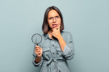 Ağzı ve gözleri sonuna kadar açık, eli çenesinde genç İspanyol bir kadın. Hoş olmayan bir şok geçiriyor.