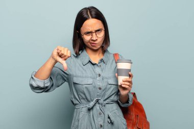 Genç İspanyol kadın kızgın, sinirli, hayal kırıklığına uğramış ya da canı sıkkın, ciddi bir bakışla başparmağını kaldırıyor.