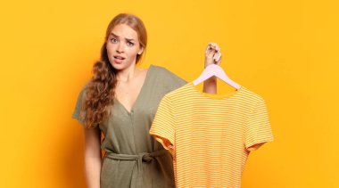 Şok olmuş ya da şaşırmış görünüyor, ağzı açık bakıyor ve 