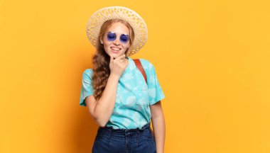 Mutlu, kendinden emin bir ifadeyle gülümsüyor, elleri çenesinde, merak ediyor ve yan tarafa bakıyor.