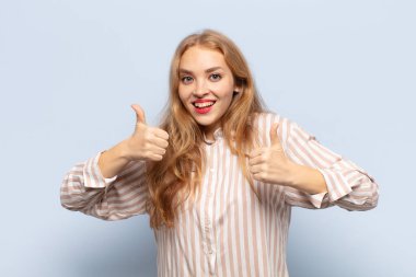 Sarışın kadın mutlu, pozitif, kendinden emin ve başarılı bir şekilde gülümsüyor.