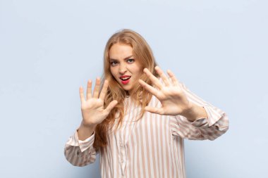 Sarışın kadın korkmuş hissediyor, korku ve panik içinde geri çekiliyor, kabusa tepki veriyor.