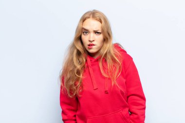 Sarışın kadın bilgisiz, kafası karışık ve hangi seçeneği seçeceğine karar verememiş, sorunu çözmeye çalışıyor.