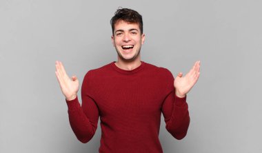 Genç adam mutlu, heyecanlı, şaşırmış ya da şaşırmış hissediyor. İnanılmaz bir şeye gülümsüyor ve şaşırıyor.