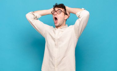 Dehşete düşmüş ve şok olmuş gibi görünen ağzı açık genç bir adam korkunç bir hata yüzünden, el ele tutuşuyor.