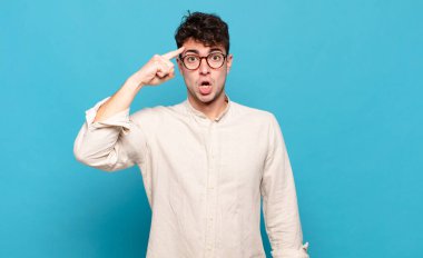 Genç adam şaşırmış, ağzı açık, şok olmuş, yeni bir düşünce, fikir ya da konsept keşfediyor.