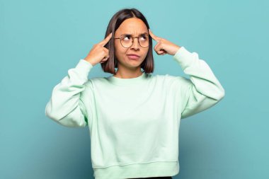 Genç İspanyol kadın kafası karışmış ya da şüpheye düşmüş, bir fikre odaklanmış, çok düşünüyor, kenarda boşluğu kopyalamak istiyor.