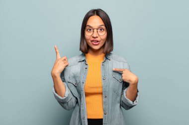 Genç İspanyol kadın kendini gururlu ve şaşırmış hissediyor. Kendine güvenerek kendini bir numara gibi hissediyor.