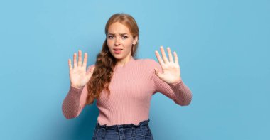 Sarışın, güzel bir kadın sersemlemiş ve korkmuş hissediyor. Korkutucu bir şeyden korkuyor. Elleri açık ve uzak dur diyor.