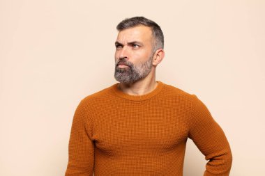 Yetişkin yakışıklı bir adam kafası karışmış ve kafası karışmış görünüyor. Bir sorunu çözmeye çalışıyor ya da çözmeye çalışıyor.