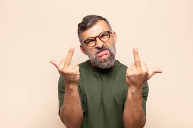 Yetişkin, yakışıklı bir adam kışkırtıcı, agresif ve müstehcen bir tavırla orta parmağını hareket ettiriyor.