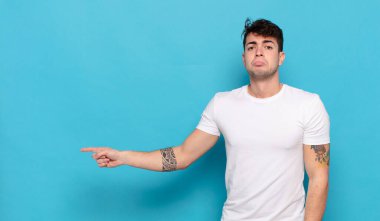 Mavi arka planda genç yakışıklı adam