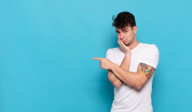 Mavi arka planda genç yakışıklı adam