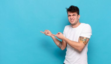 Mavi arka planda genç yakışıklı adam